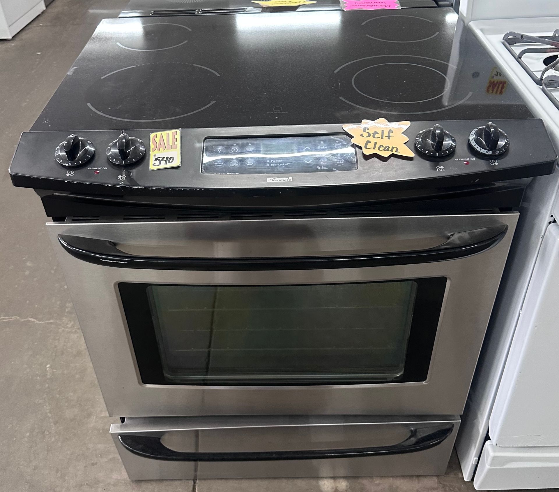Black freestanding electric stove with oven and four burners in an appliance store