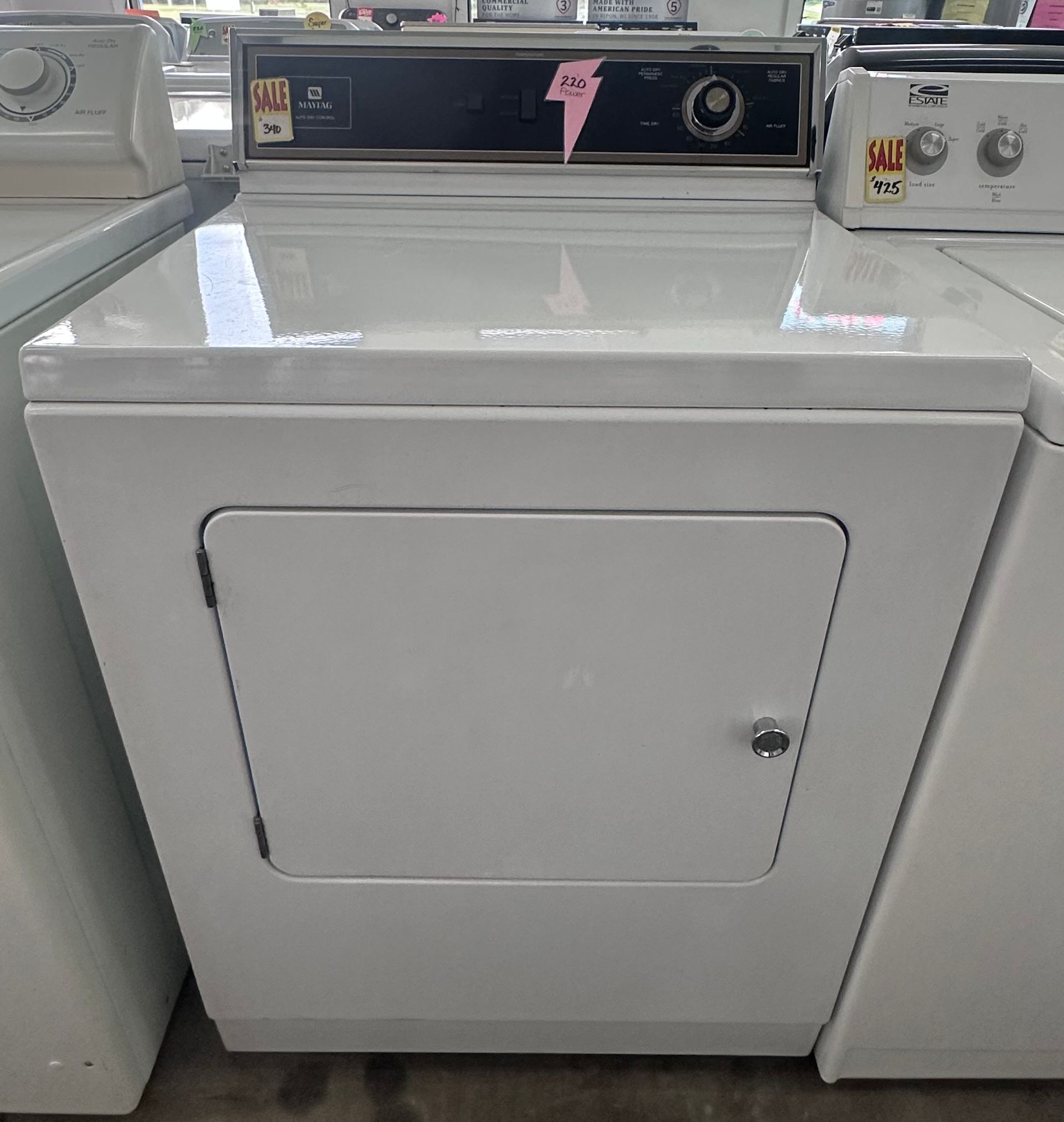 White Samsung front-load washing machine with a glass top, on display in a store.