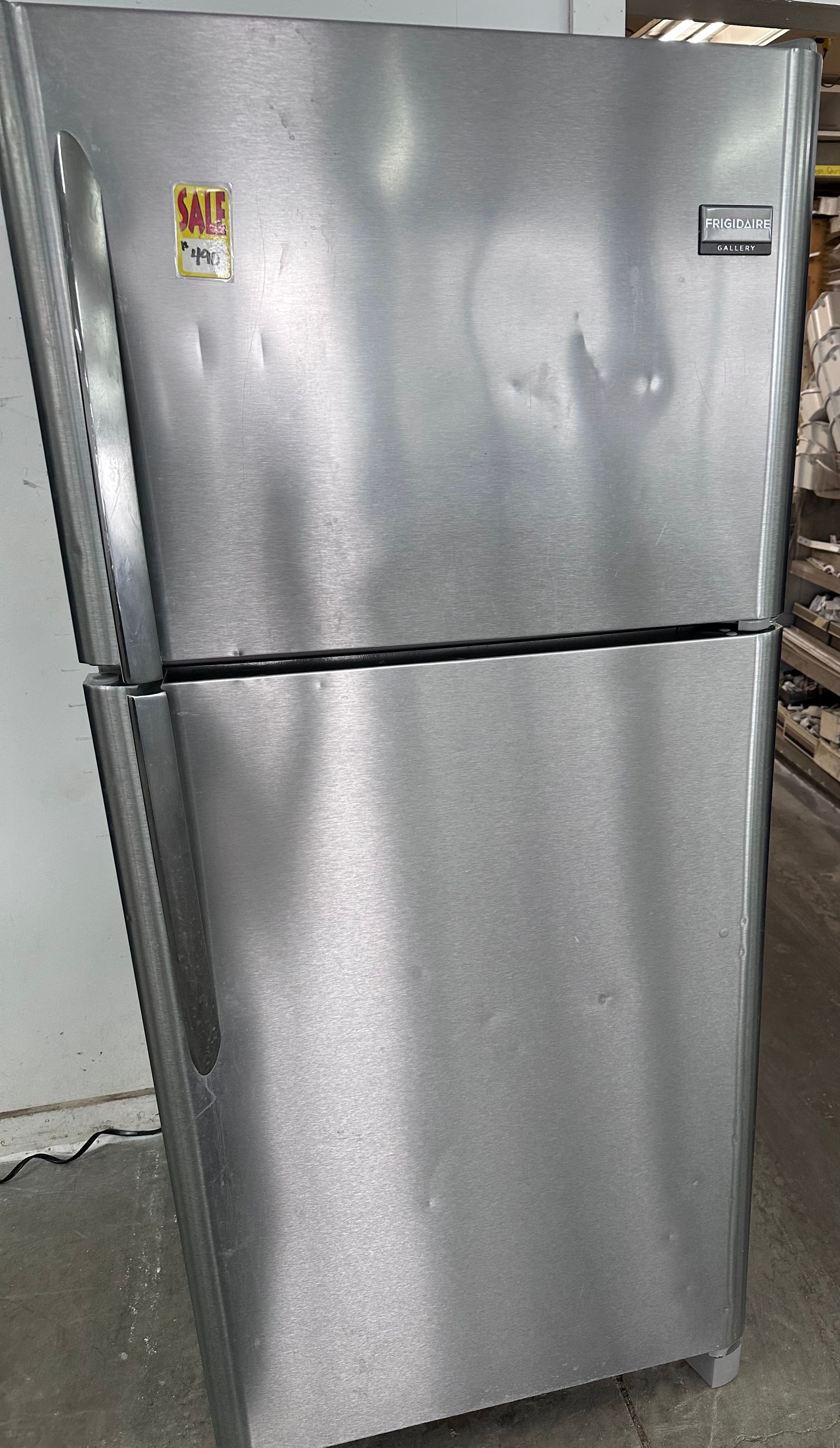 Stainless steel Frigidaire refrigerator with dents.