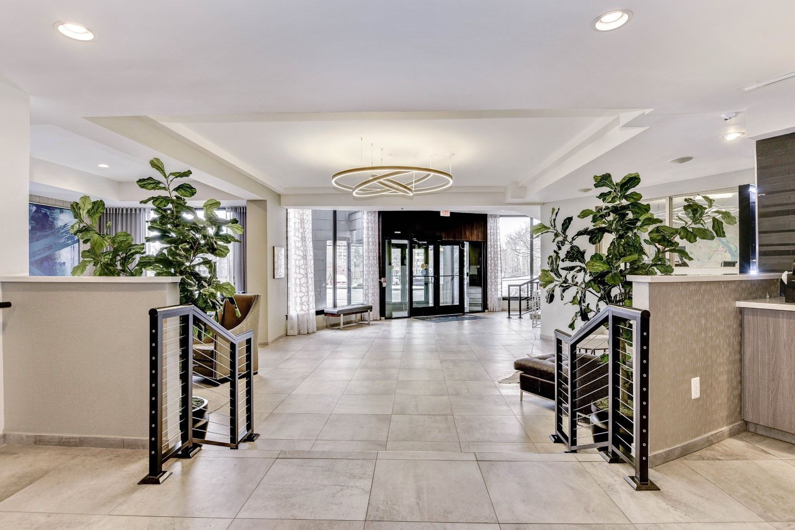 A large lobby with a staircase leading up to the entrance at The Mark by Solaire in Alexandria, VA.