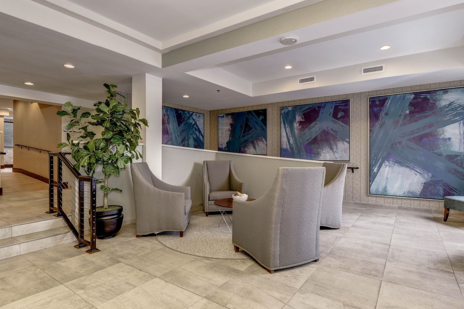 A lobby with chairs , a table and a plant at The Mark by Solaire in Alexandria, VA.