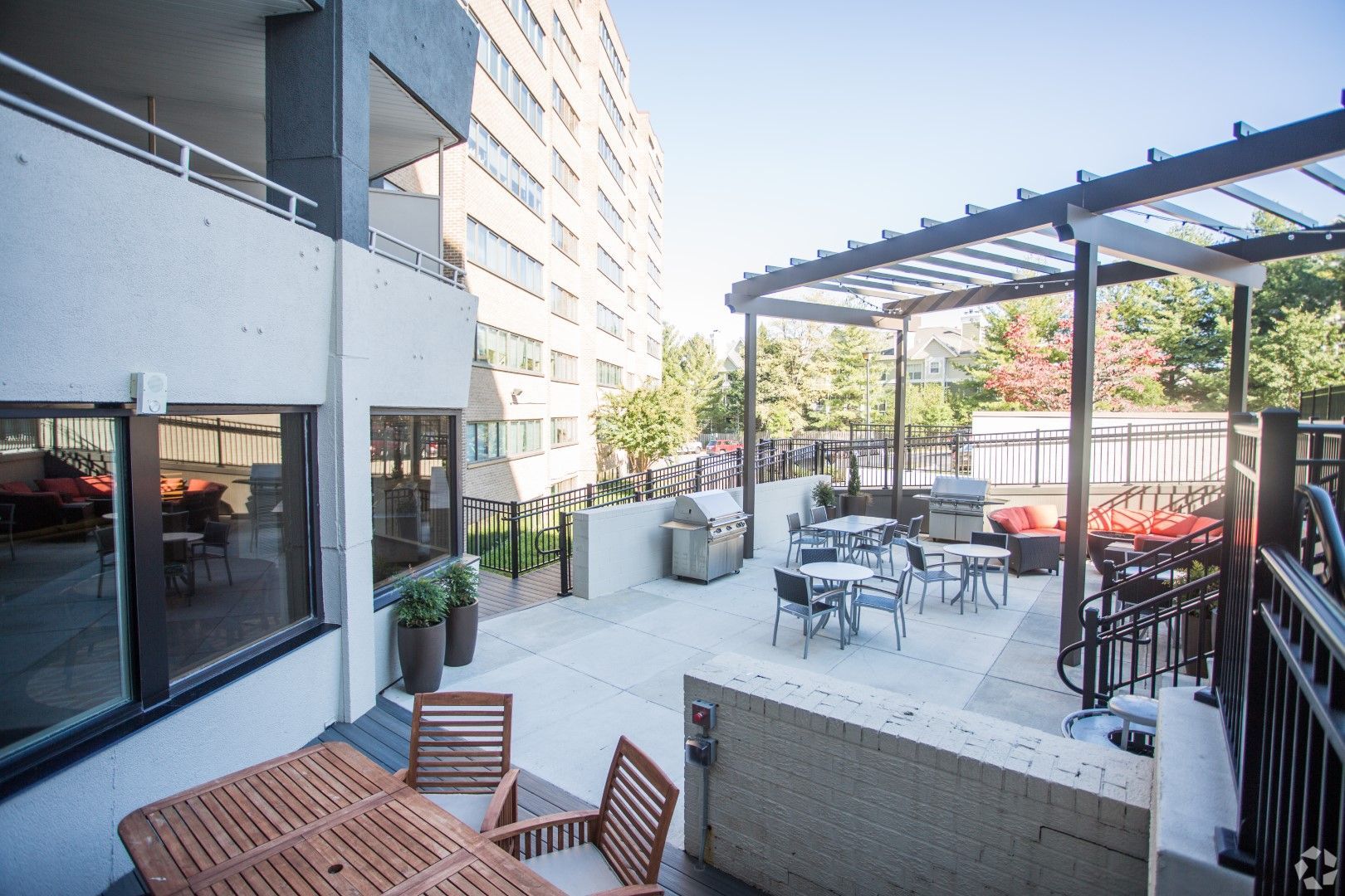 A patio with tables and chairs in front of a building at The Mark by Solaire in Alexandria, VA.