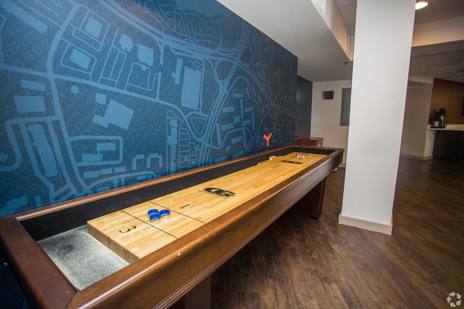 A shuffleboard table in a room with a map on the wall at The Mark by Solaire in Alexandria, VA.