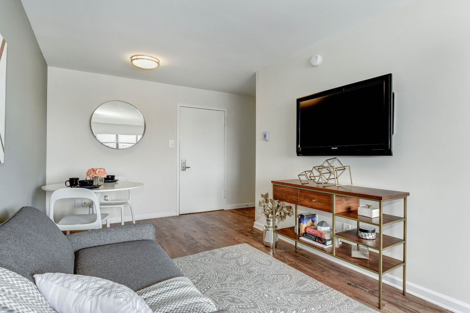 A living room with a couch and a flat screen tv on the wall at The Mark by Solaire in Alexandria, VA.