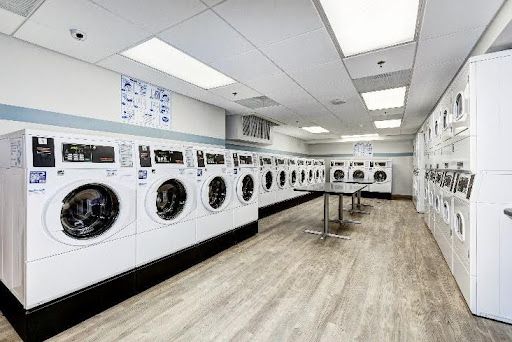 A laundromat filled with lots of washing machines and dryers.