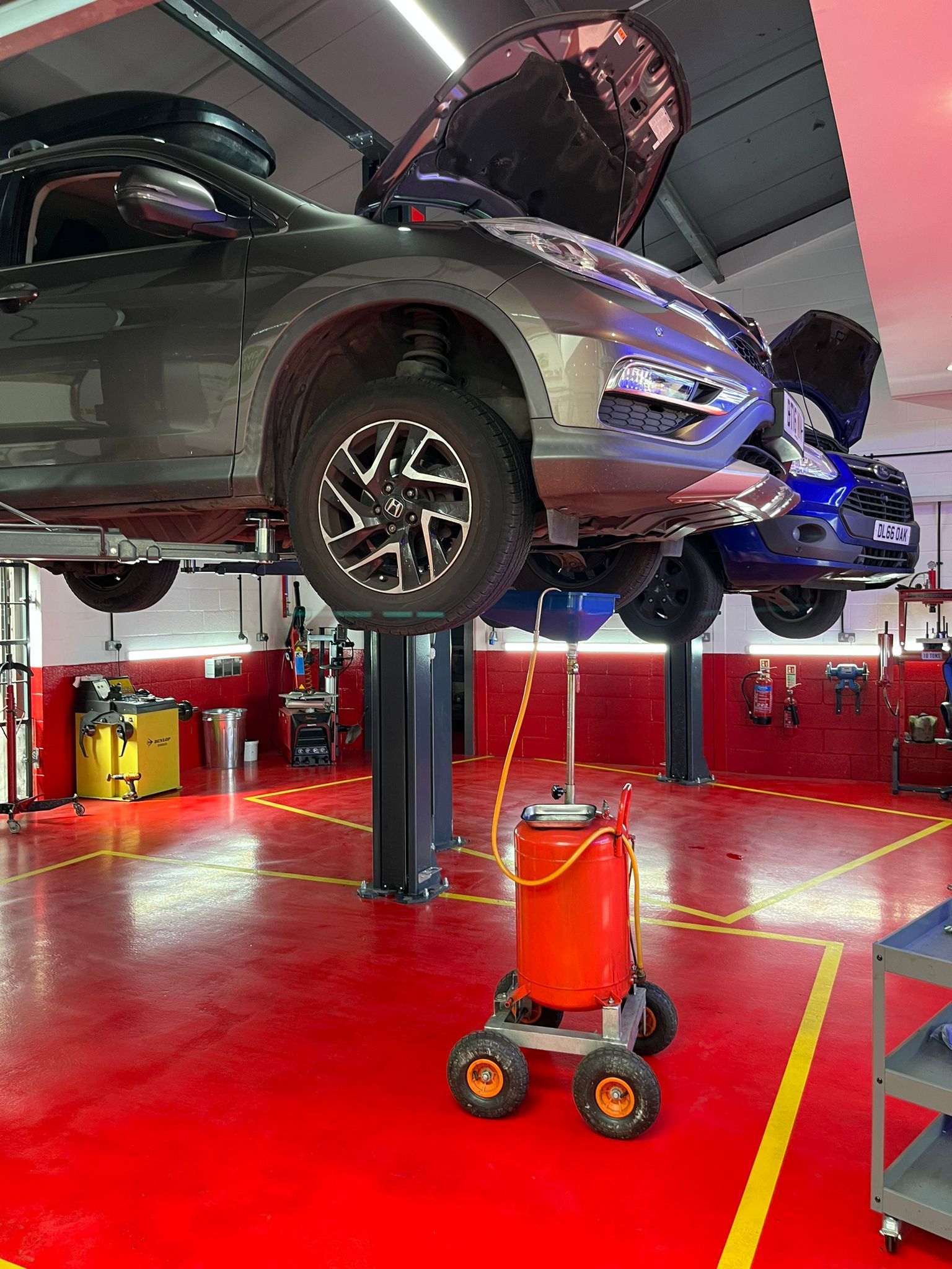 A car is sitting on a lift in a garage.