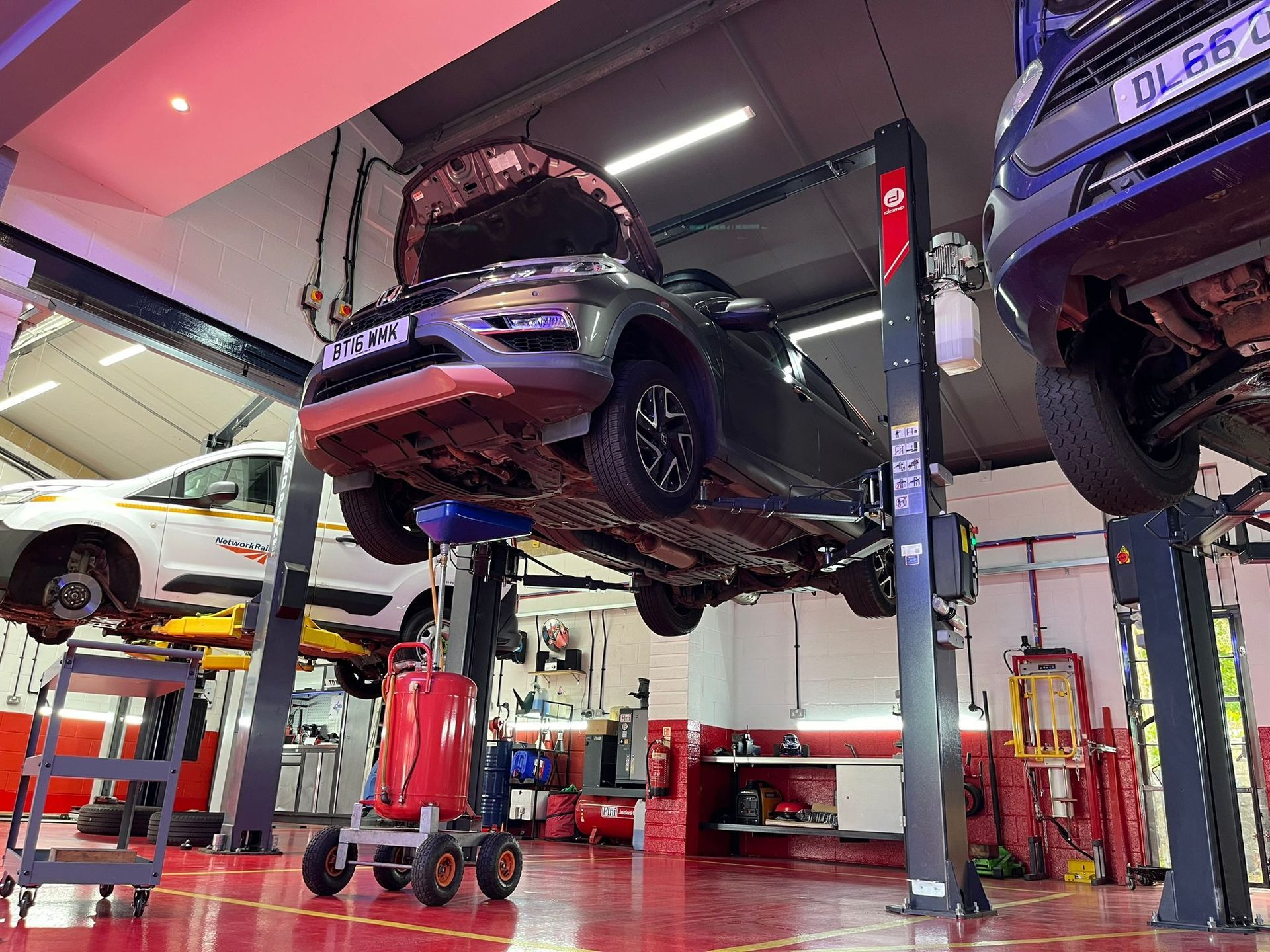 A car is sitting on a lift in a garage.