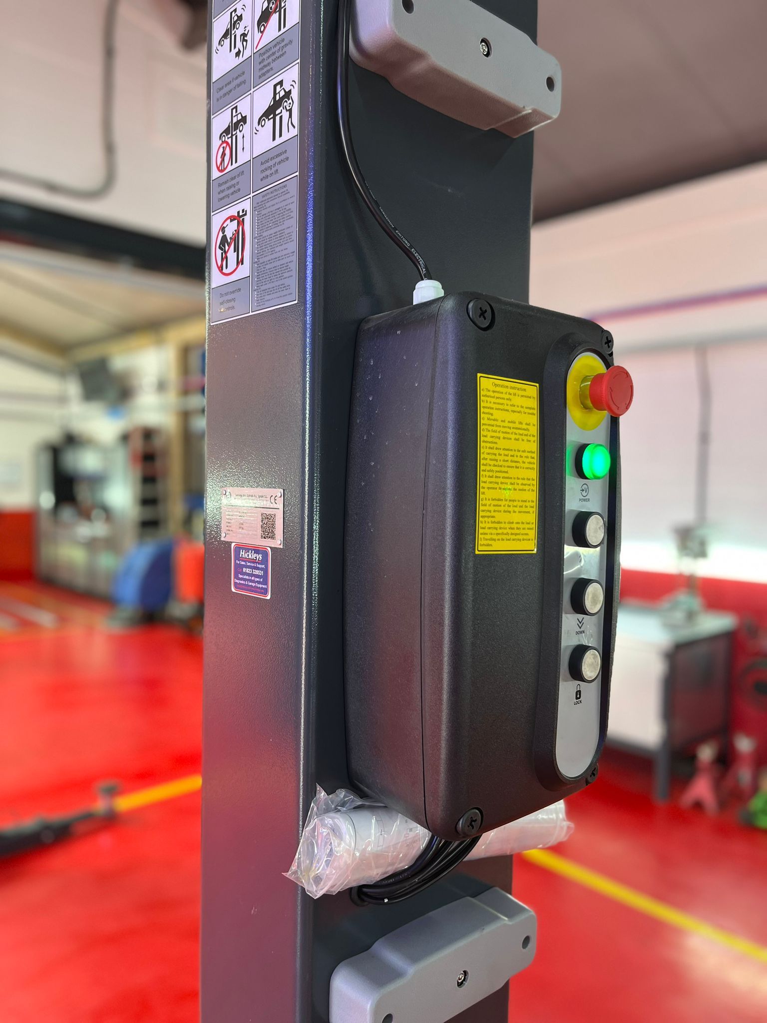 A close up of a remote control on a pole in a garage.