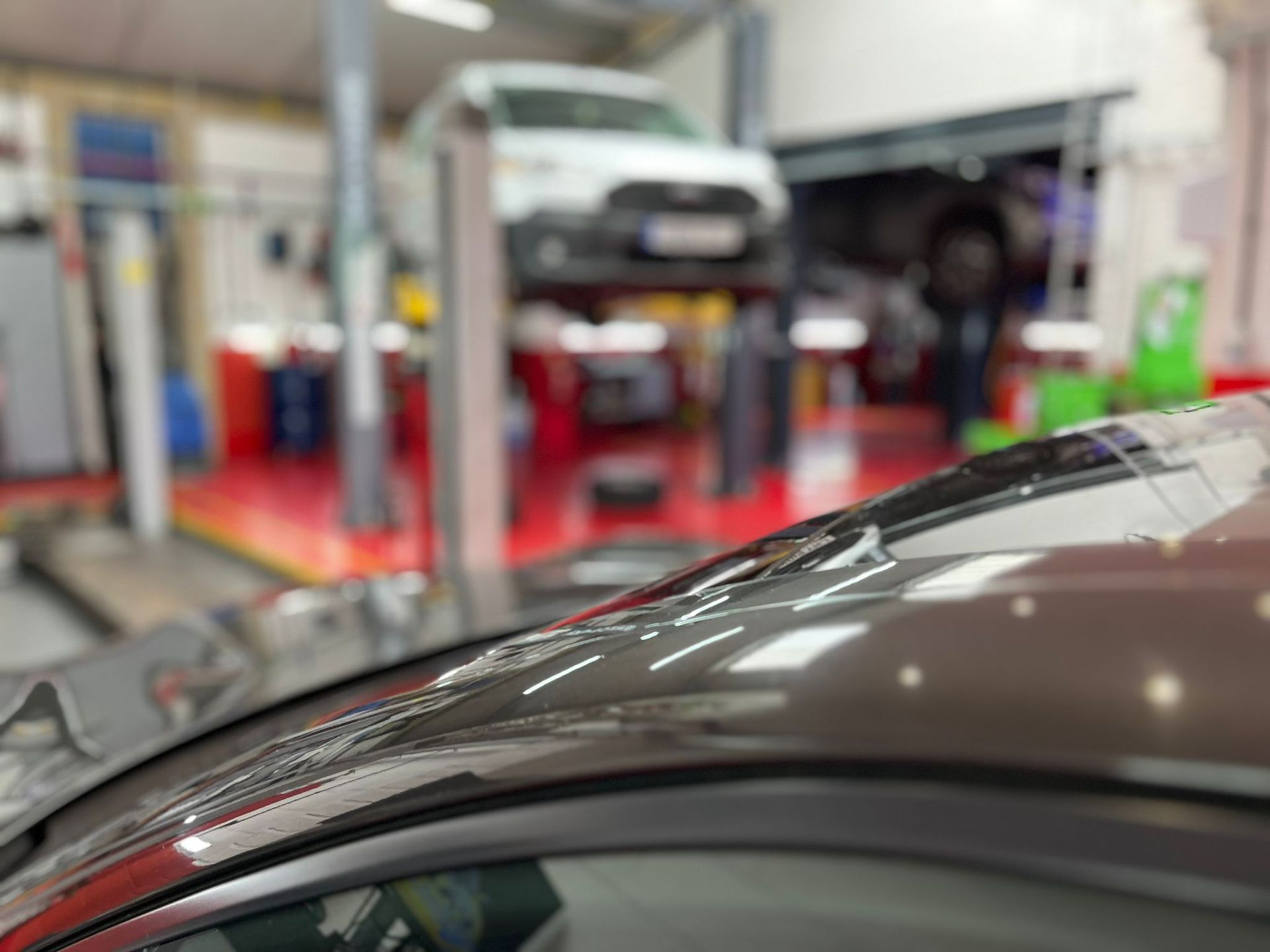 A car is sitting on a lift in a garage.