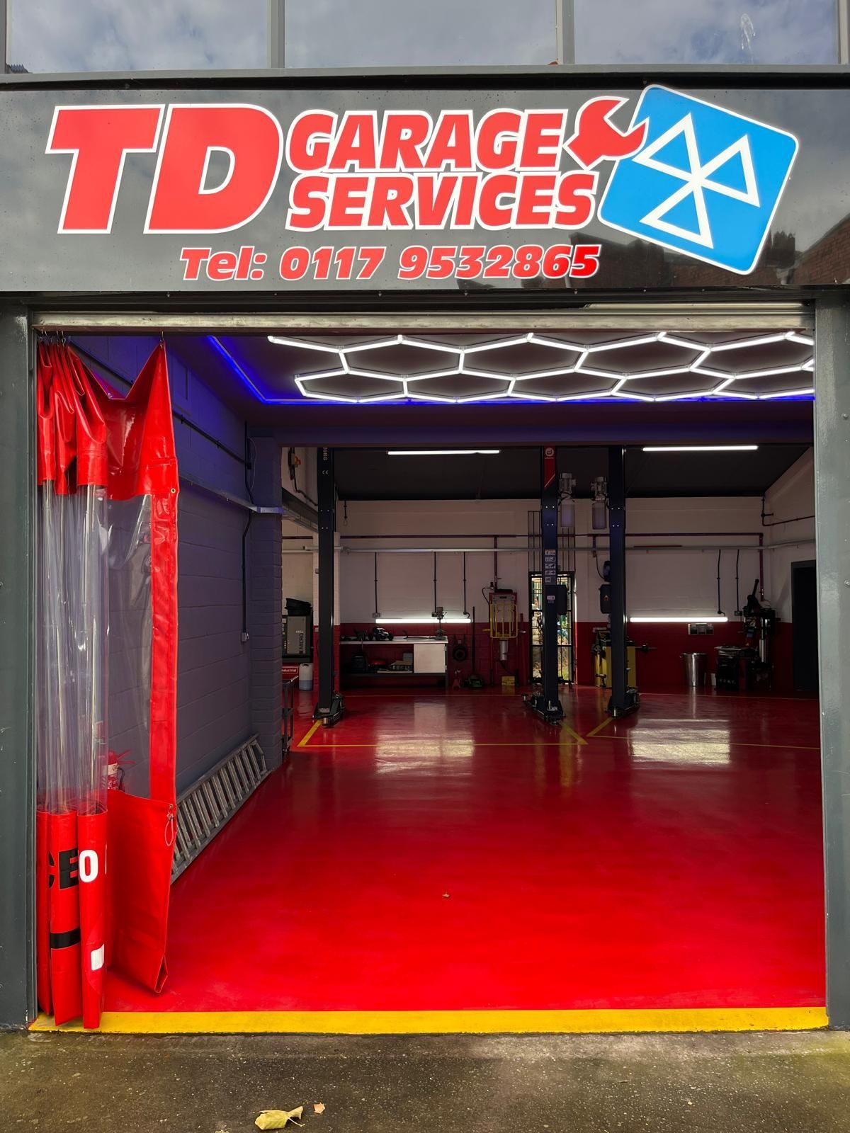 A garage with a red floor and a sign that says td garage services.