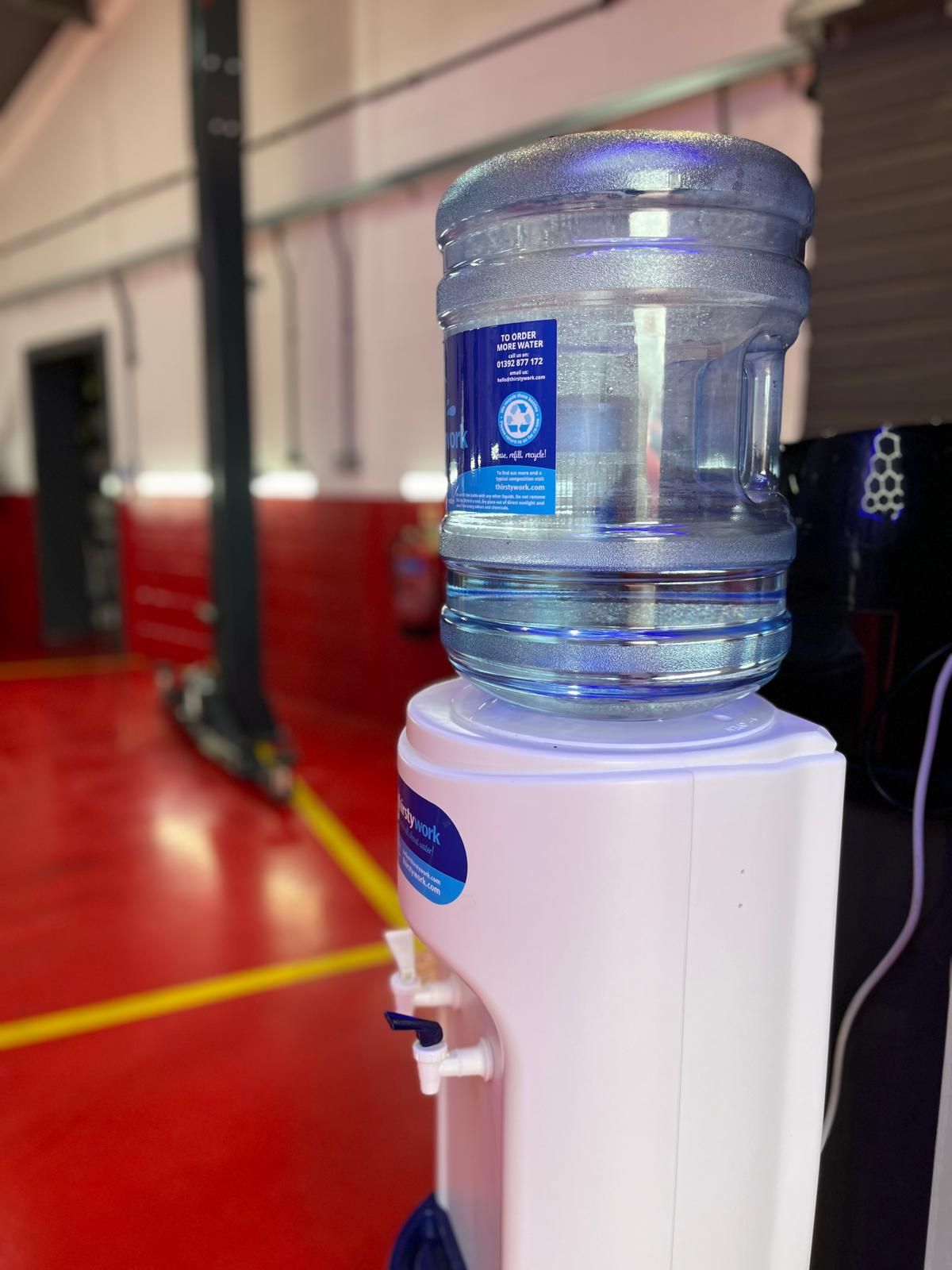 A bottle of water is sitting on top of a water dispenser.
