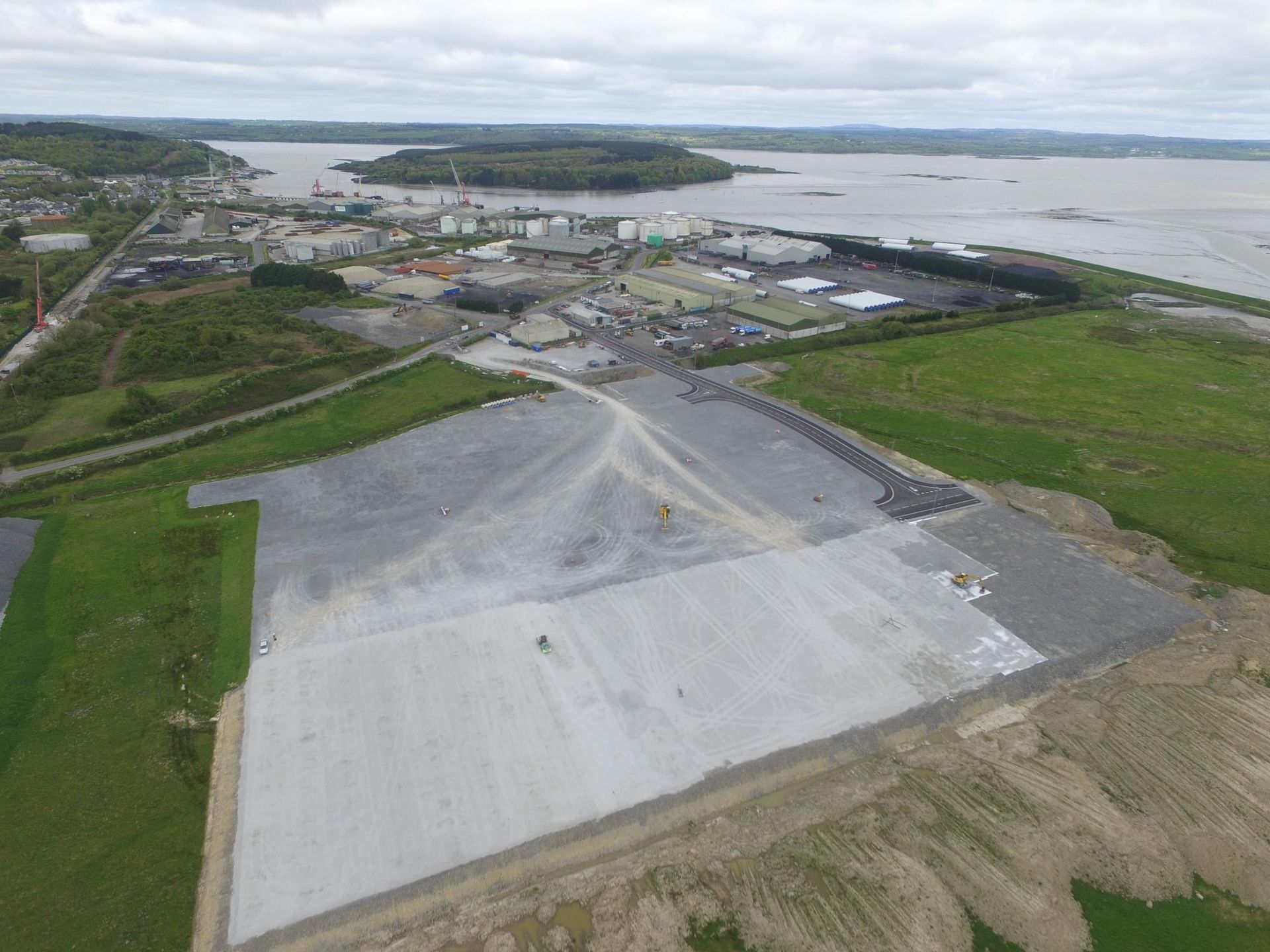 An aerial view of a large area with a large body of water in the background
