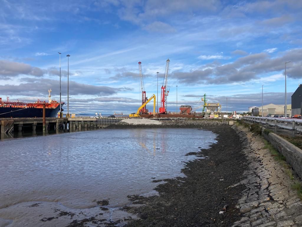 A large ship is docked at a dock near a body of water
