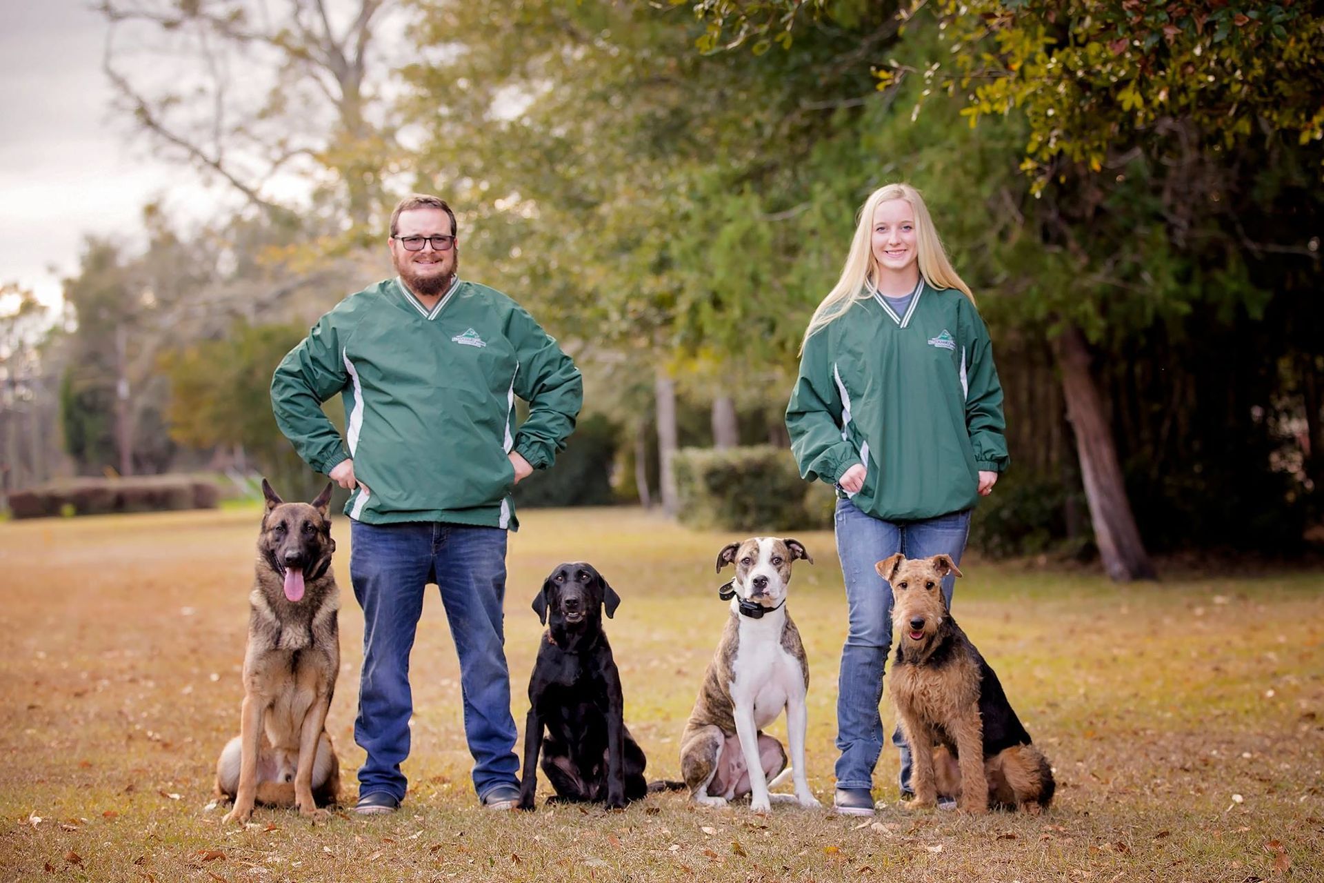 a group of people standing next to a sign that says altamaha canine athletics
