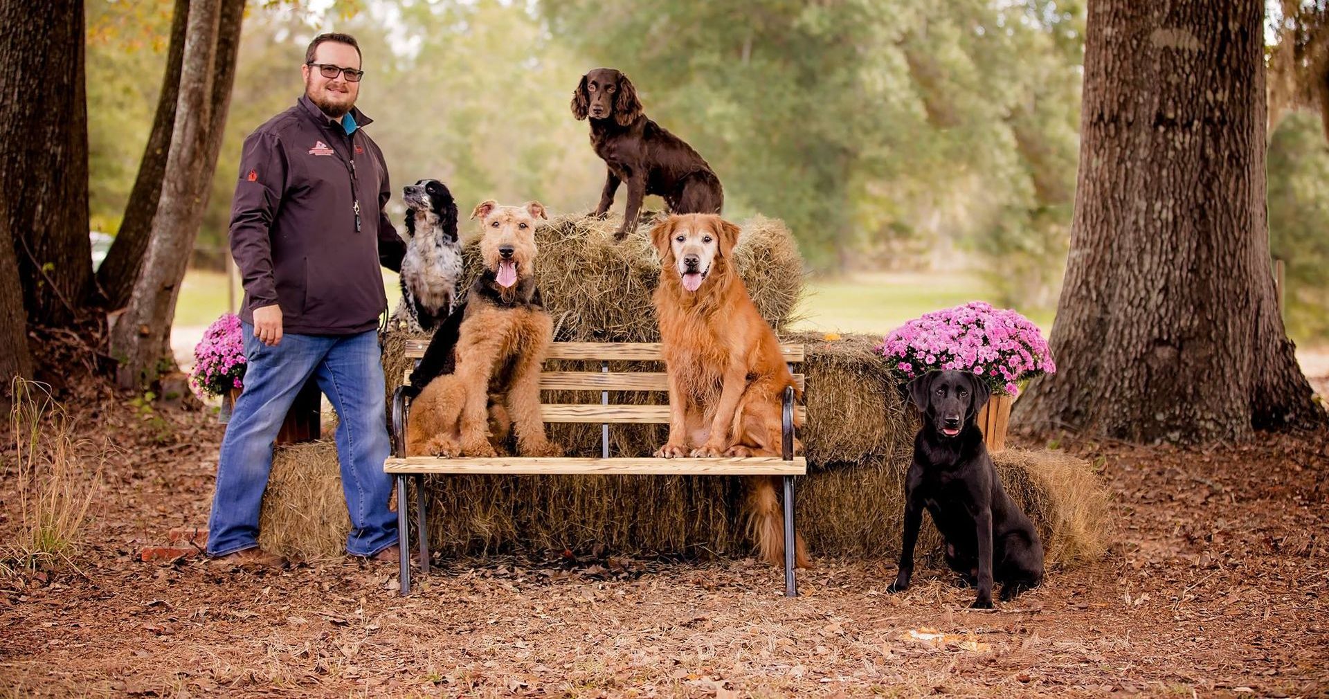 a man and a woman are standing next to their dogs