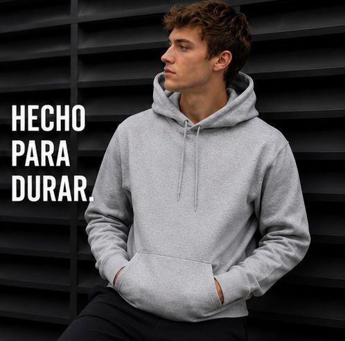 Joven con sudadera gris sobre fondo oscuro con el texto: “HECHO PARA DURAR”.