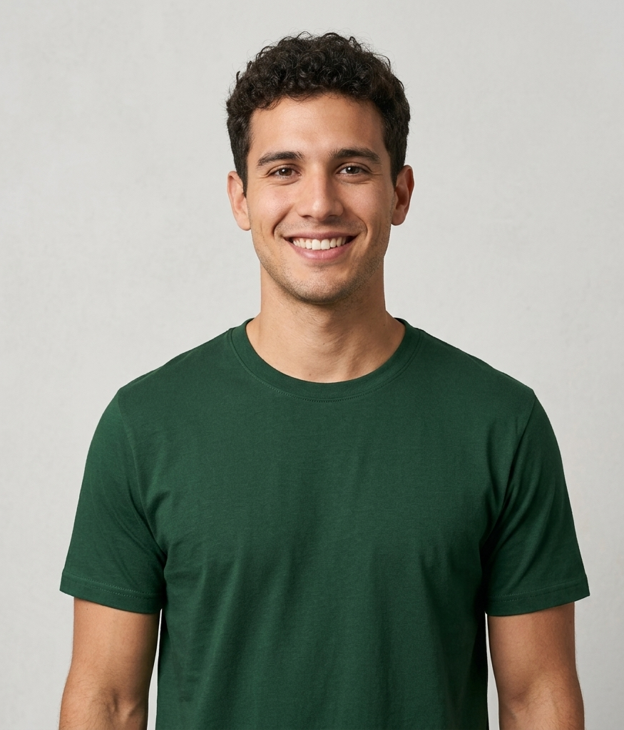 Persona sonriente con una camiseta verde oscuro sobre un fondo gris claro.