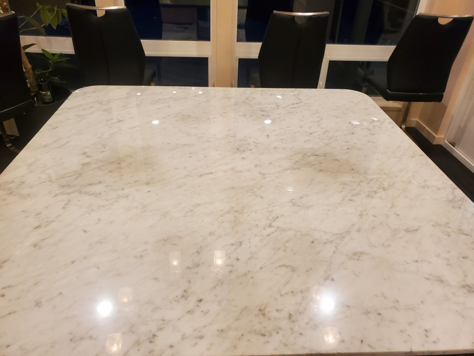 Marble tabletop in a café or dining area with chairs in the background