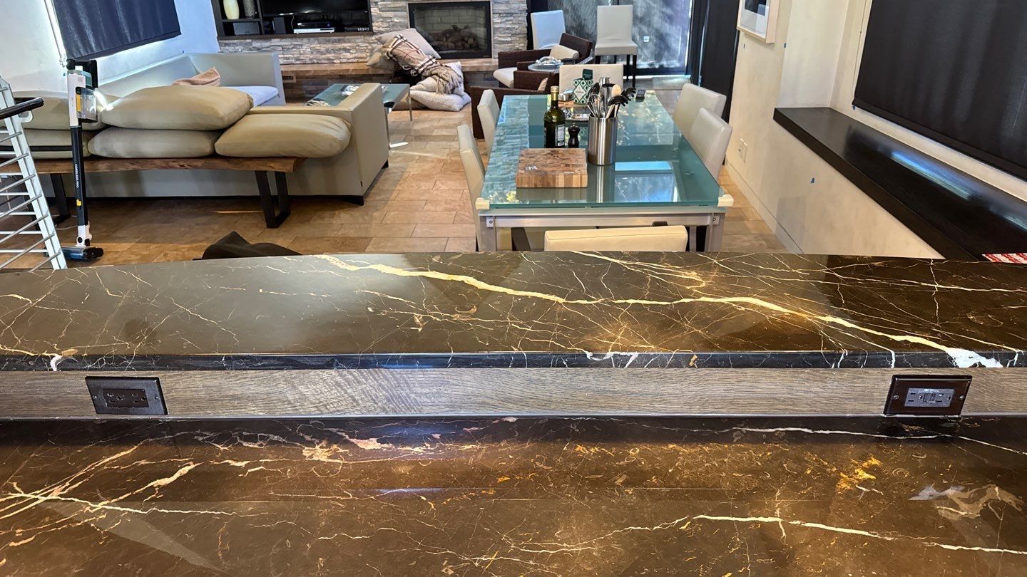 White tiled wall above beige marble baseboard and dark wood floor, with a cardboard box at right edge
