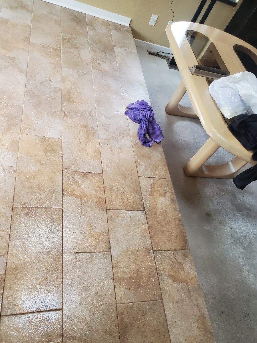 Tile and carpet floor beside a wooden chair, with a purple cloth on the floor.