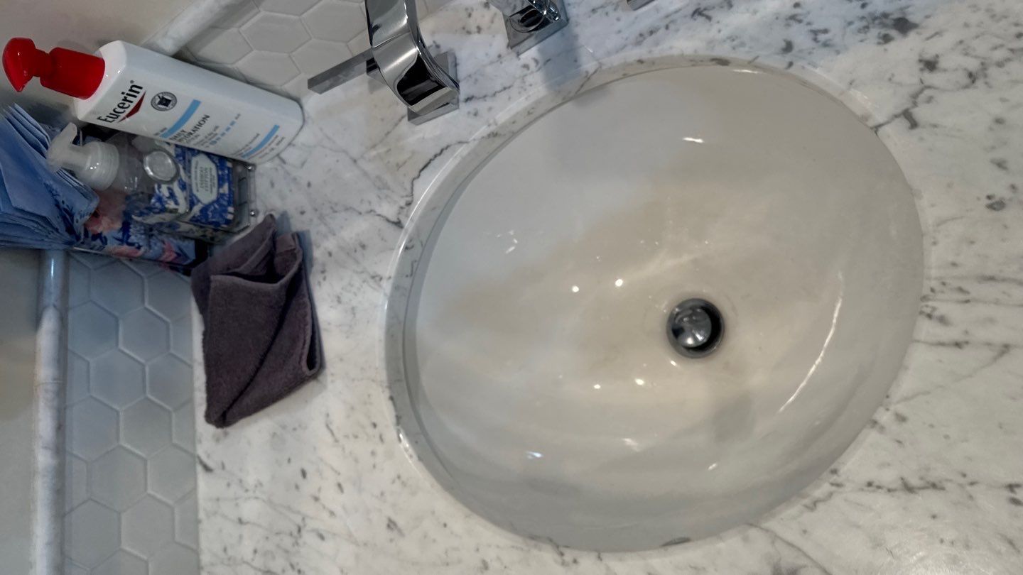White double-sink bathroom vanity with mirror and marble floor tiles.