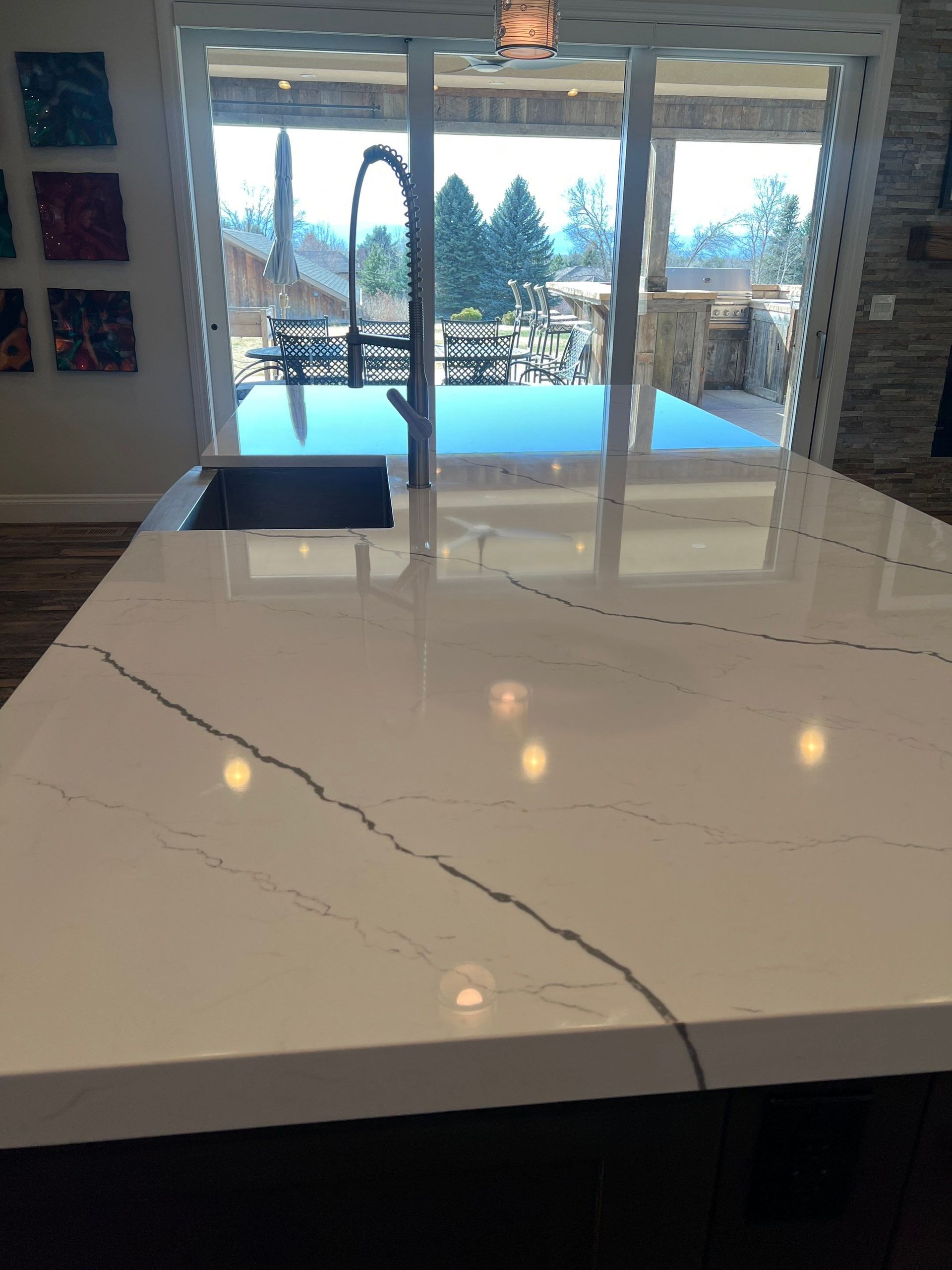 Modern kitchen with dark glossy tile floor, white cabinets, oven, and built-in refrigerator cabinets