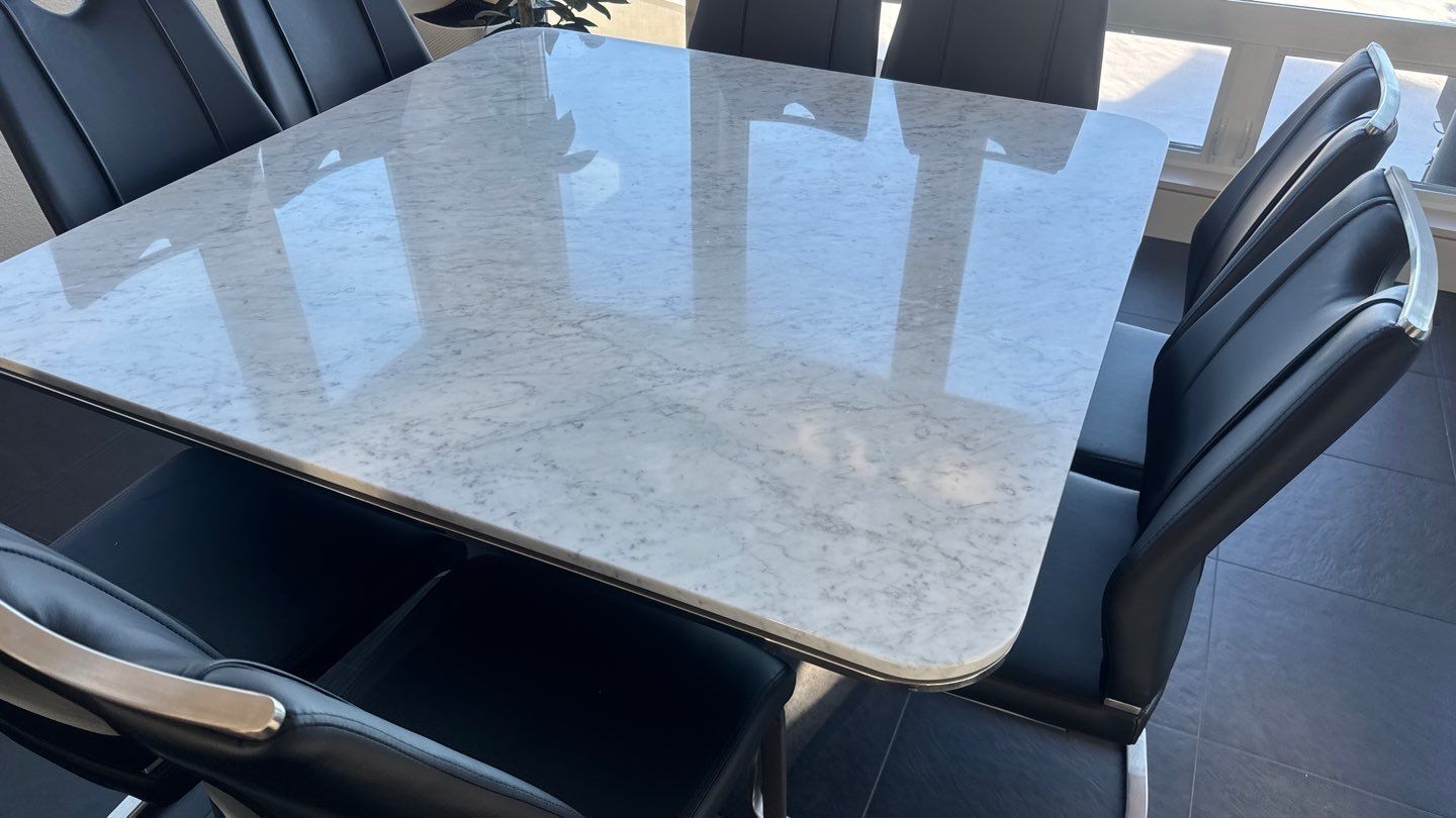 Marble-look kitchen island countertop with gray base and wood floor below