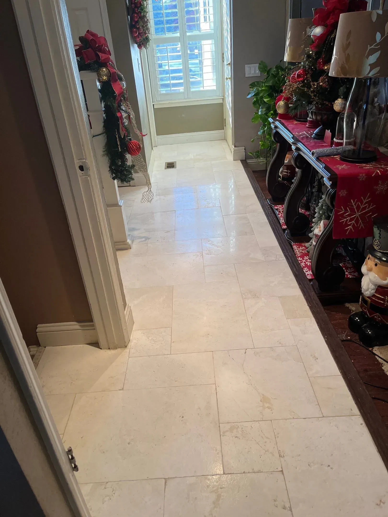 Decorated hallway with holiday garlands and a bright window at the end