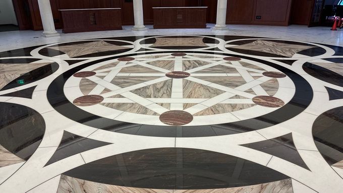 Marble countertop reflecting lights, with a large window and patio furniture in the background.
