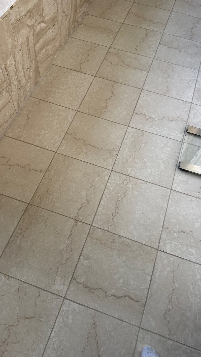 Narrow tiled hallway floor with multicolored square tiles beside a doorway and storage bins
