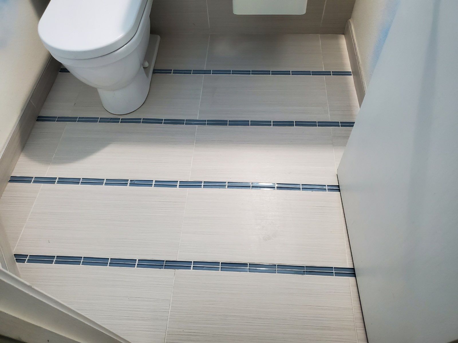 White double-sink bathroom vanity with mirror and marble floor tiles.