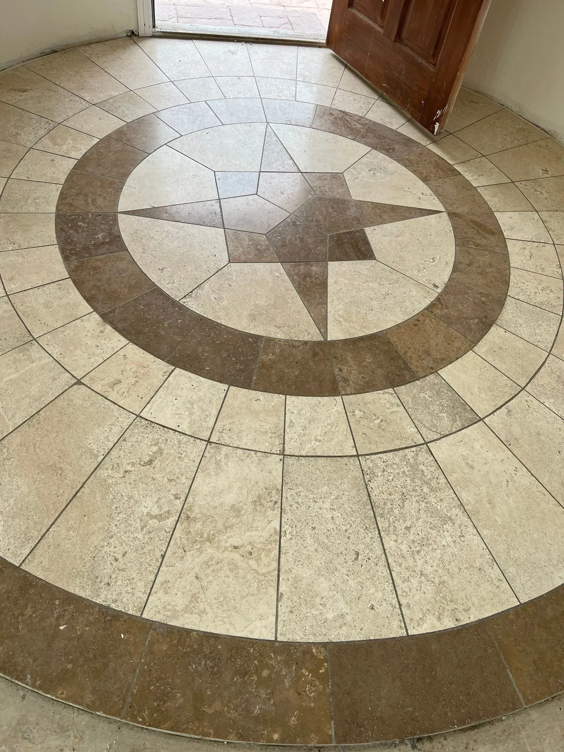 Circular stone floor mosaic with a star pattern near a doorway