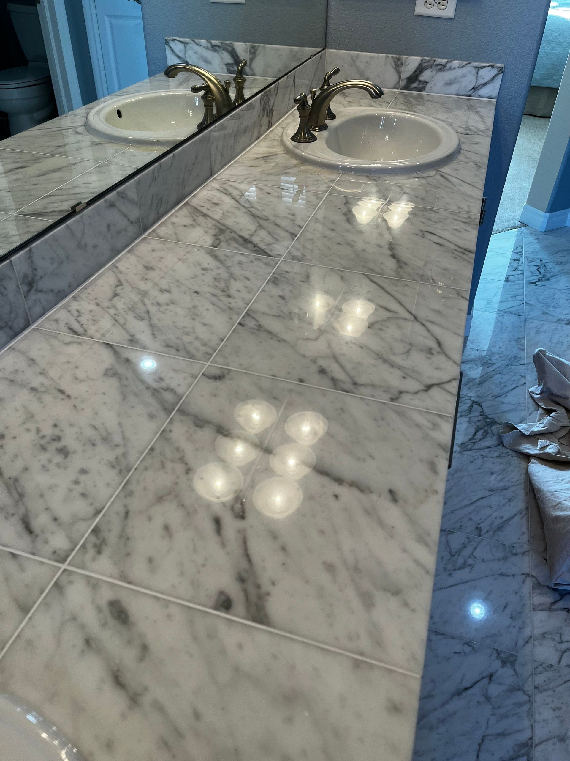 Large white marble kitchen island with dark base in a bright modern kitchen