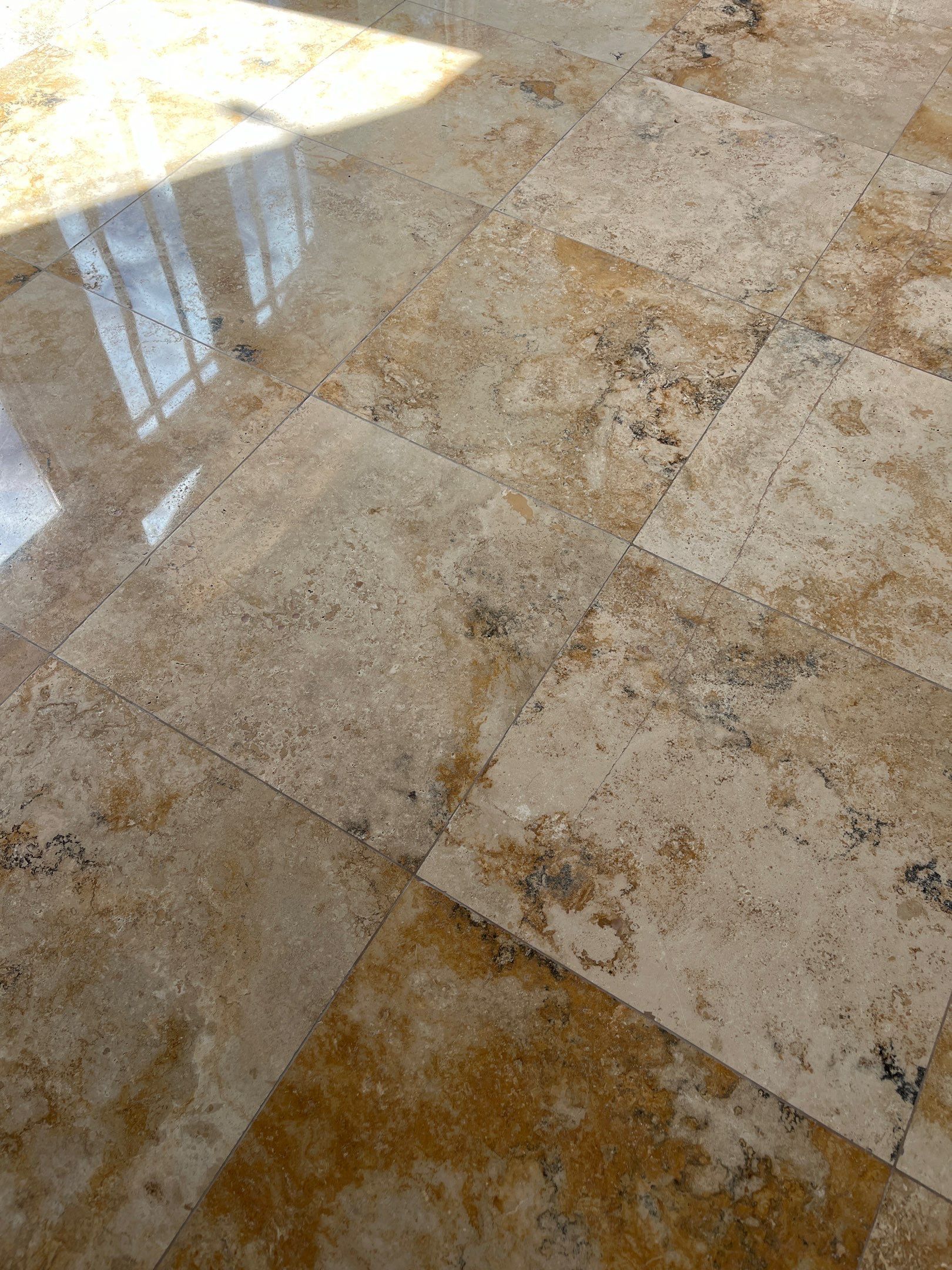 Marble-look kitchen countertop with white cabinets and tiled backsplash in a dimly lit room