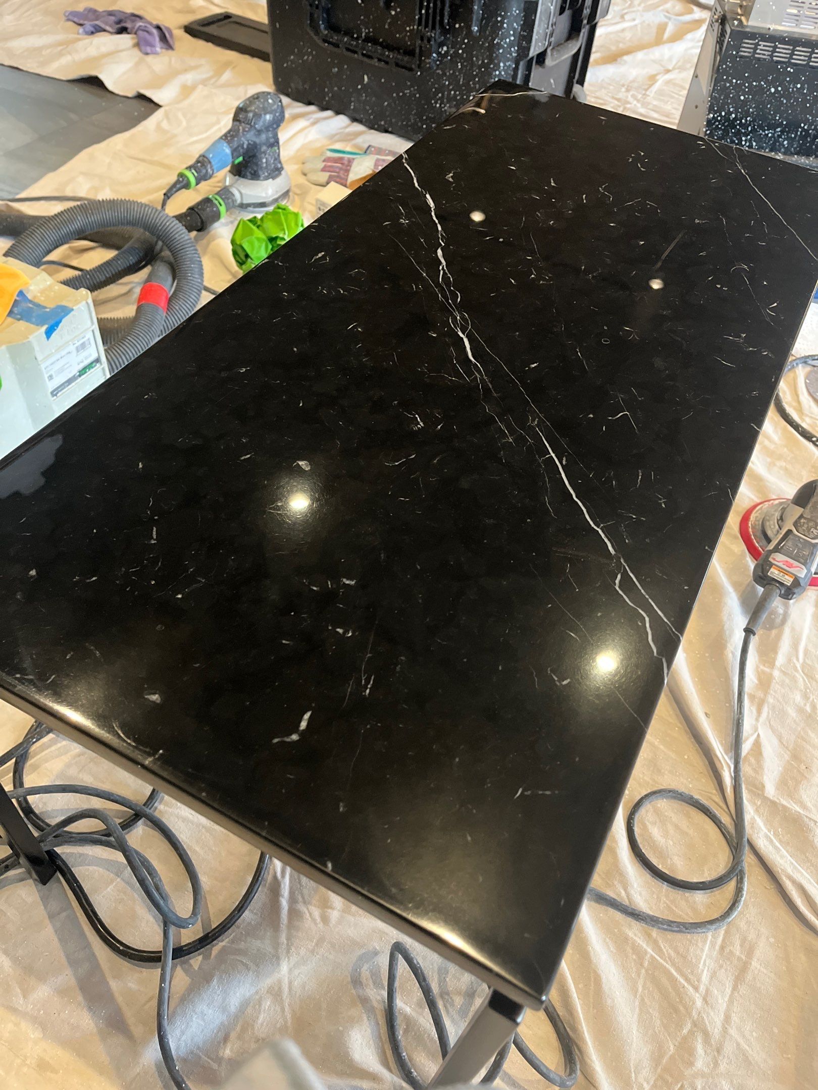 Modern kitchen with long white island countertop and a person cleaning the floor in the background