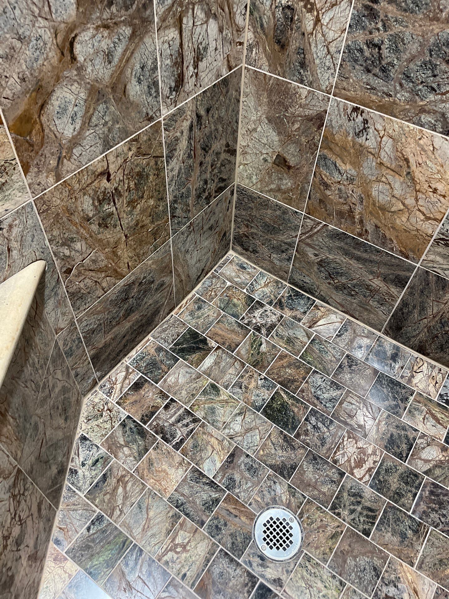 White bathtub corner with tiled shower walls and a shower curtain edge