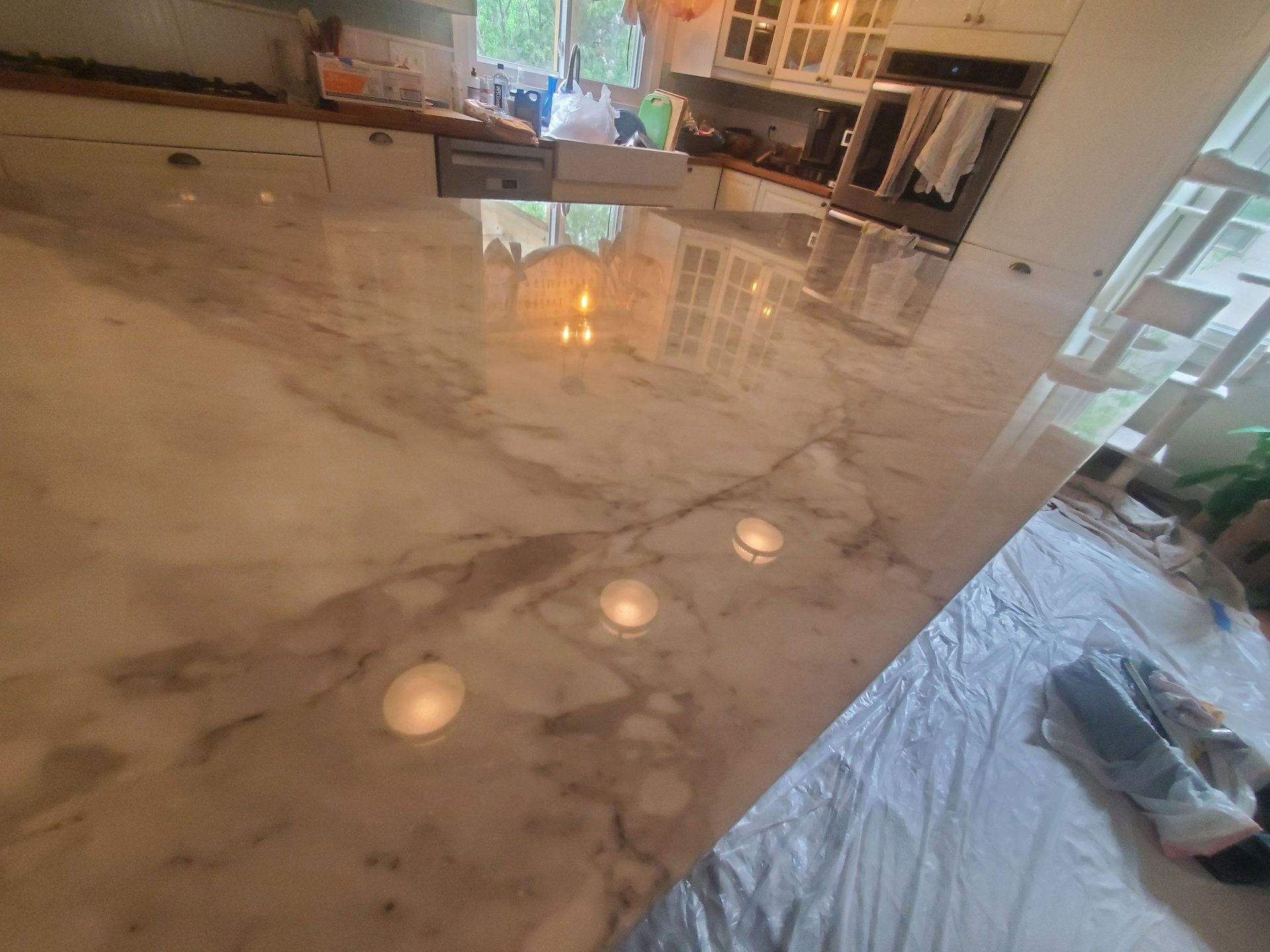 Kitchen island with speckled granite countertop, built-in sink, and hardwood floor in the background