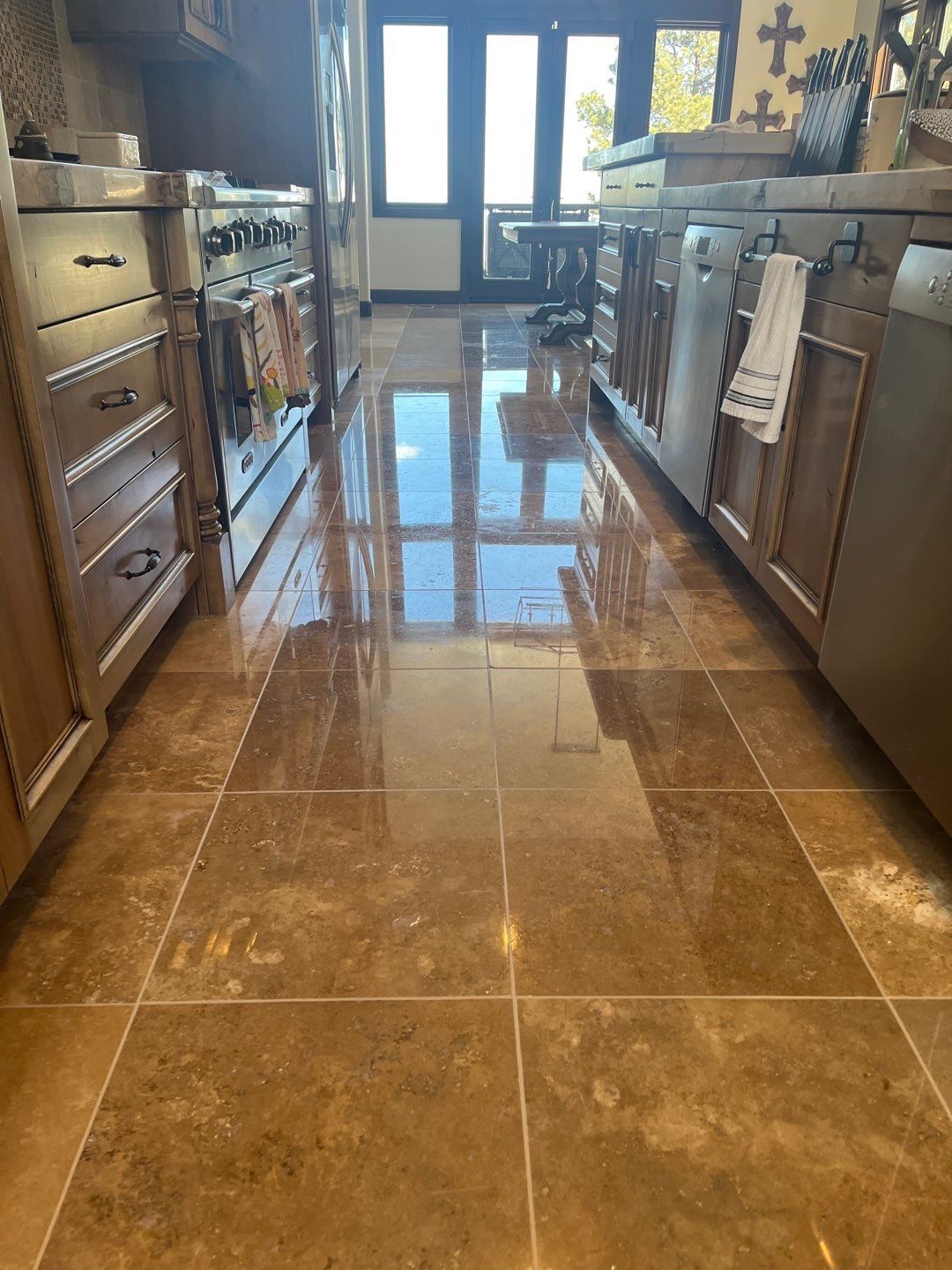 Stone-tile entryway with a wooden front door and small dark decorative inlays on the floor.