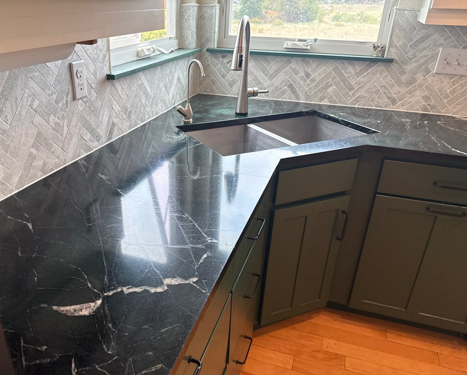 Large white marble kitchen island with dark base in a bright modern kitchen