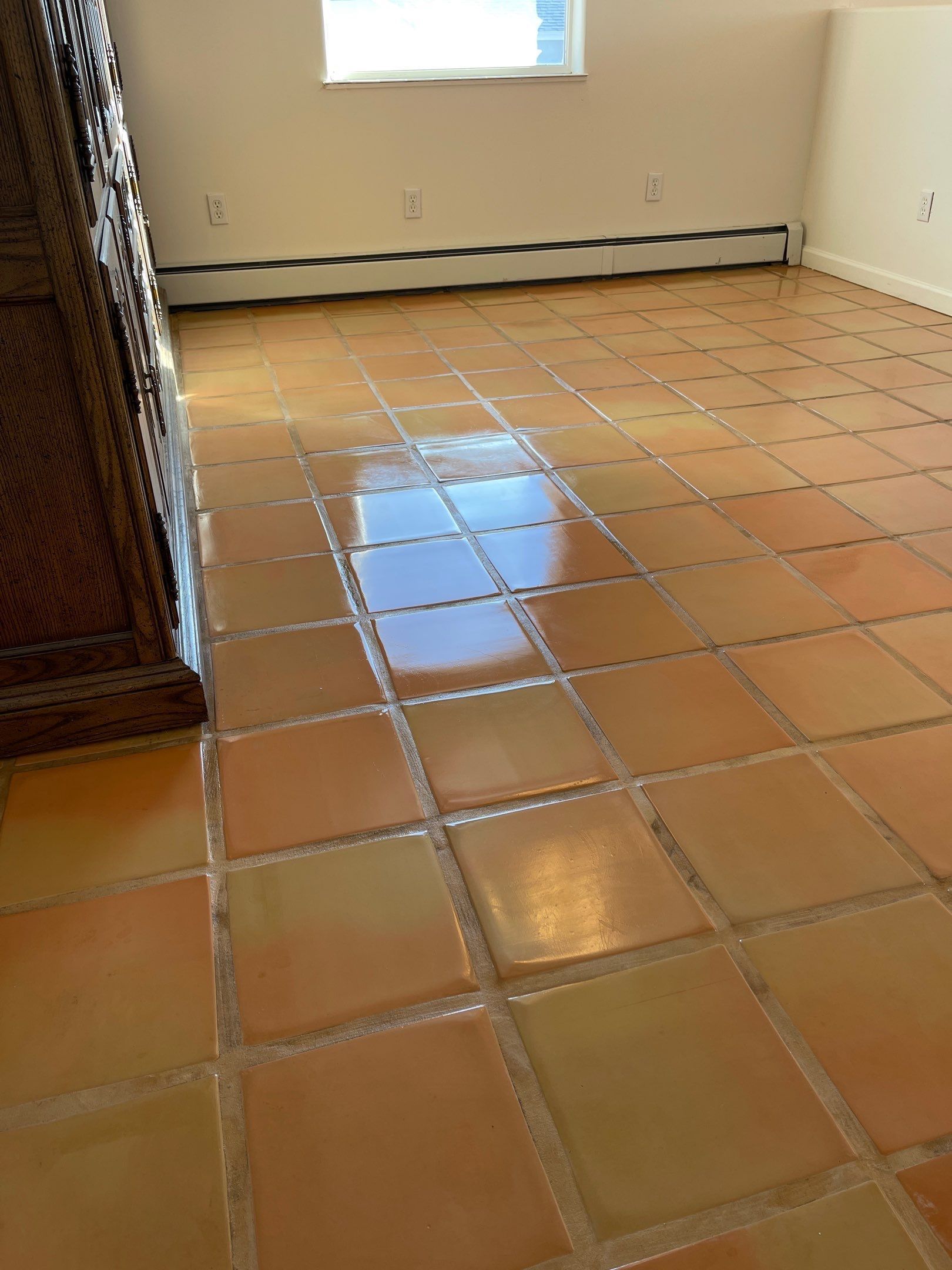 Kitchen with beige tile floor, dark wood cabinets, and sunlight streaming in from the doorway