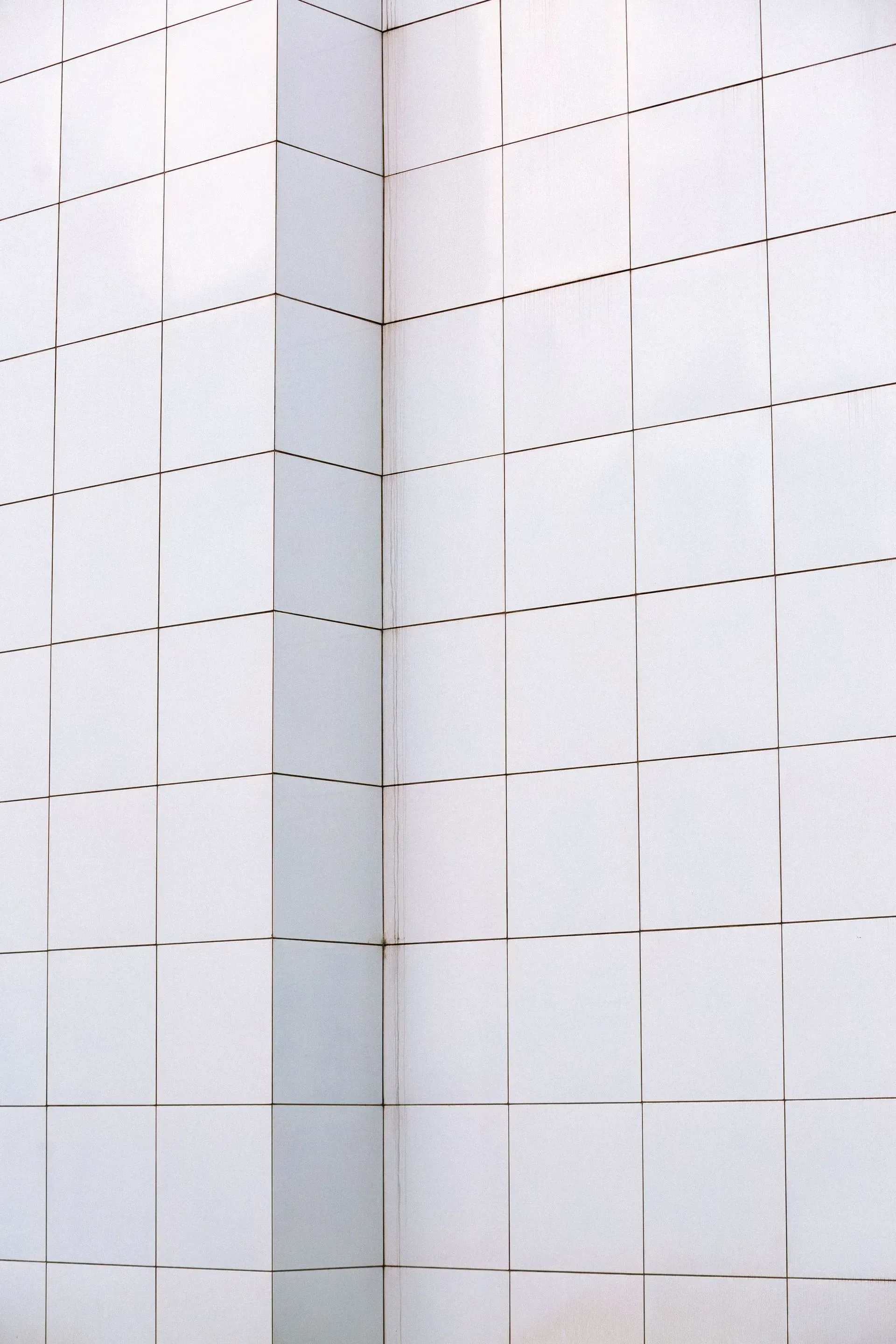 White tiled wall with scattered black dashed lines and a vertical seam down the center