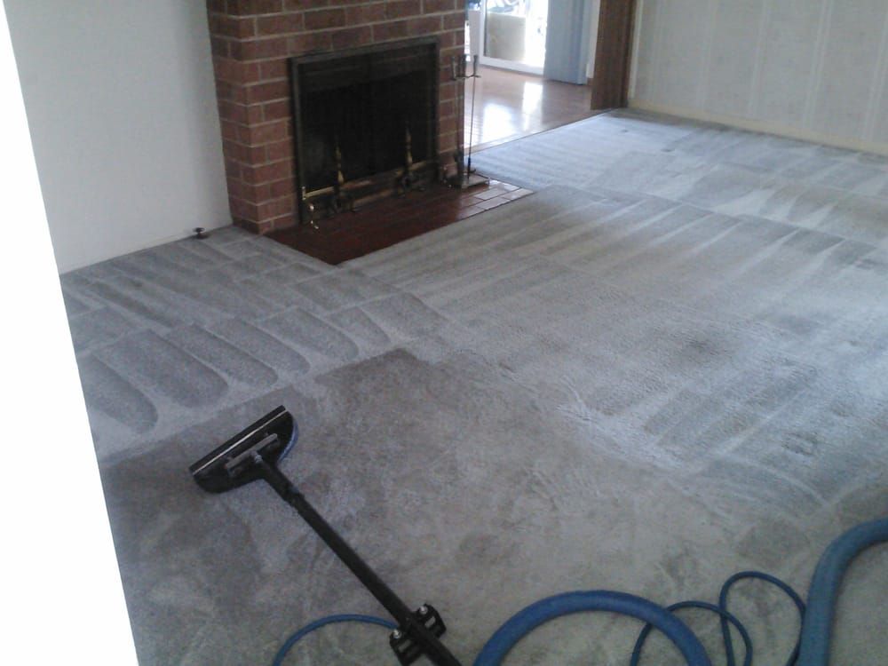 A living room with a fireplace and a vacuum on the floor