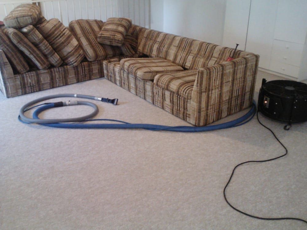 A couch with a vacuum hose attached to it