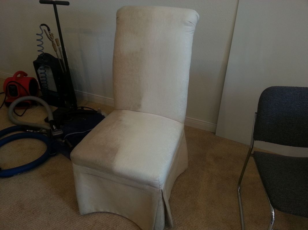 A chair is sitting in a room next to a vacuum cleaner