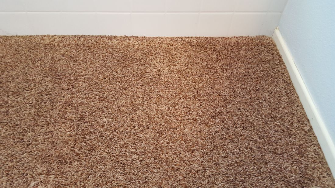 A close up of a brown carpet in a room.