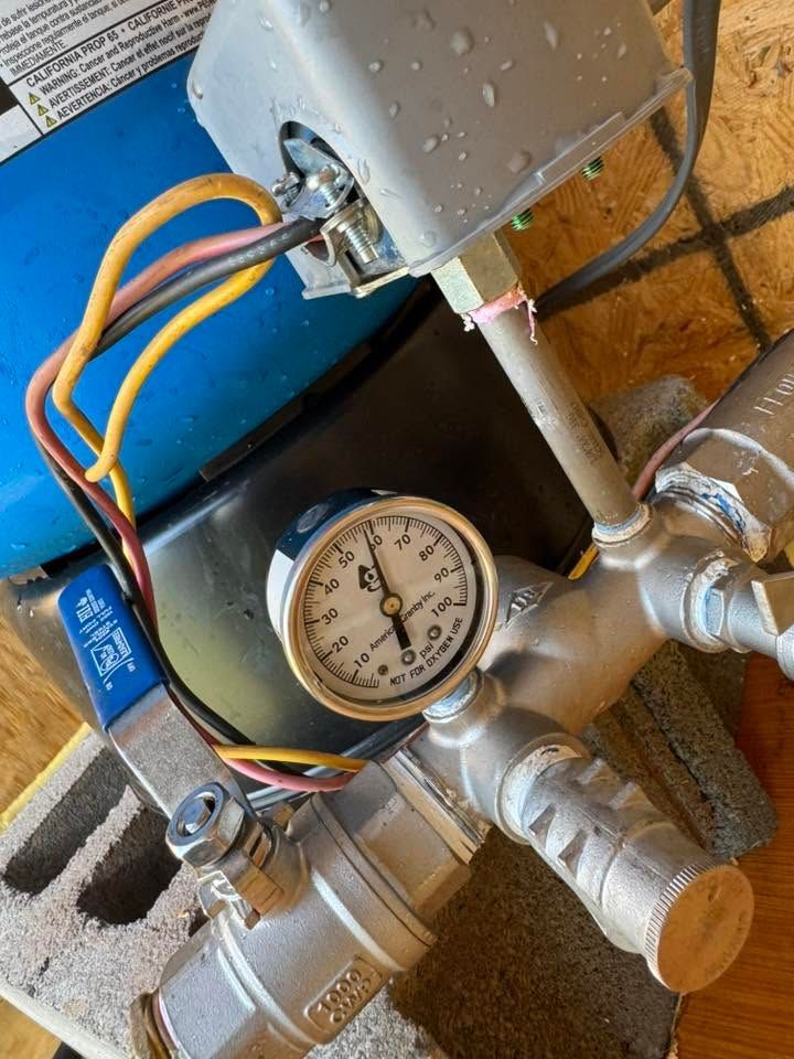 Pressure gauge and metal valves with colored wires in an industrial setup