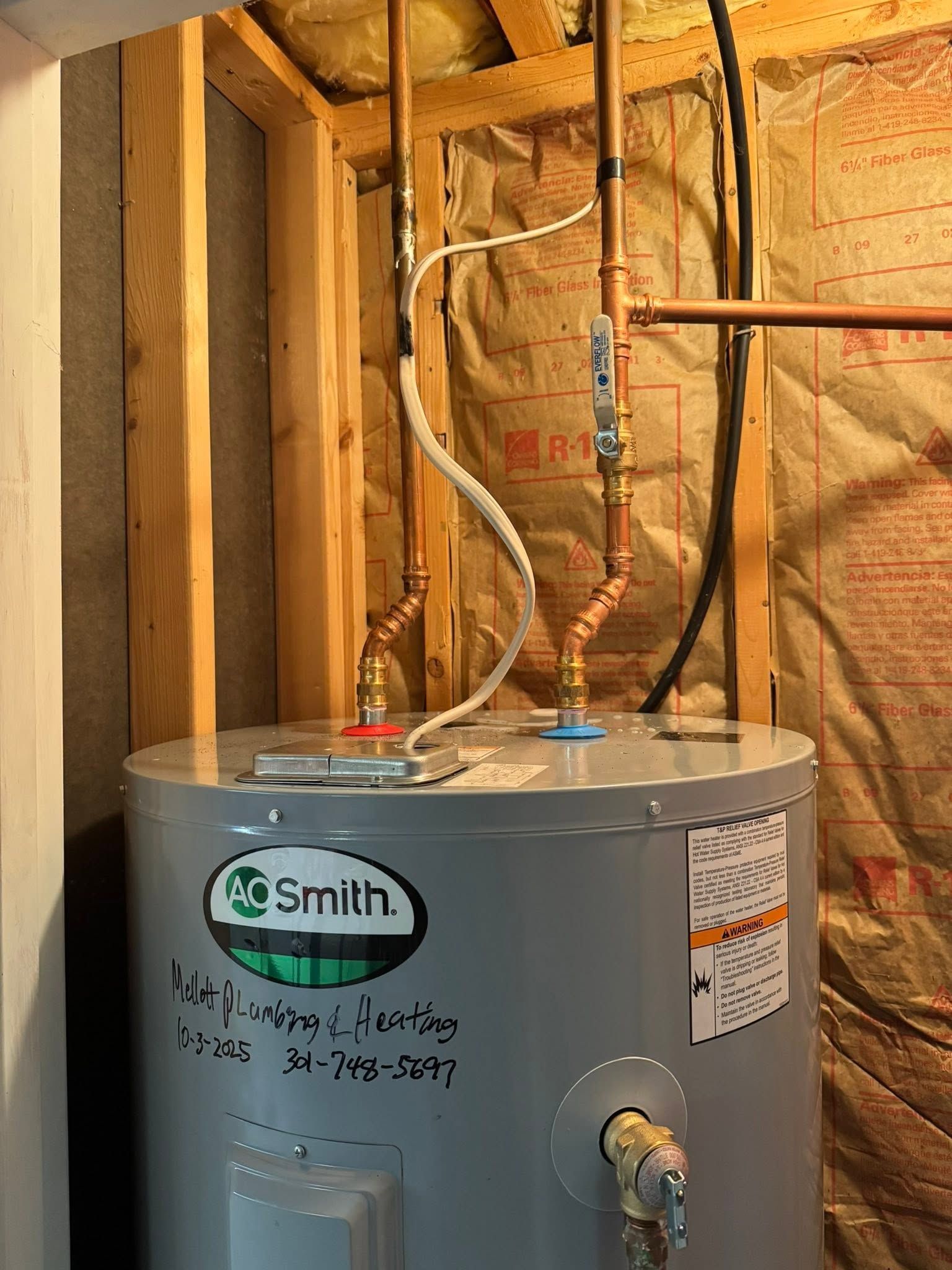AO Smith water heater in unfinished basement with exposed insulation and pipes