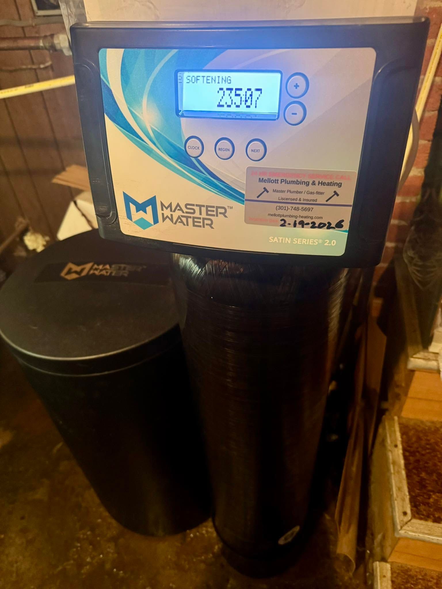 Black water filter dispenser with a digital display on a wooden floor