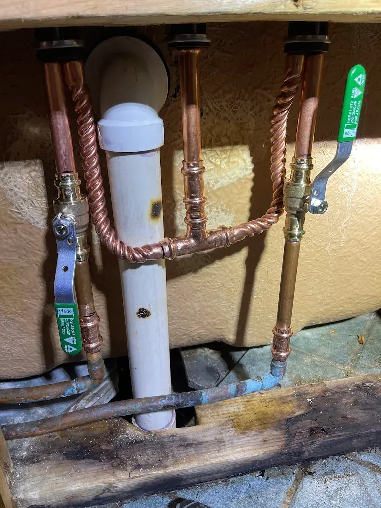 Copper pipes and green-handled valves inside an insulated mechanical unit.