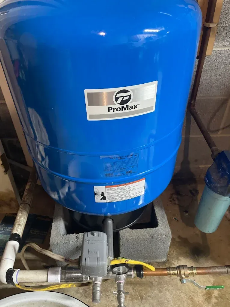 Blue ProMax pressure tank with attached pipes and valve in a utility area